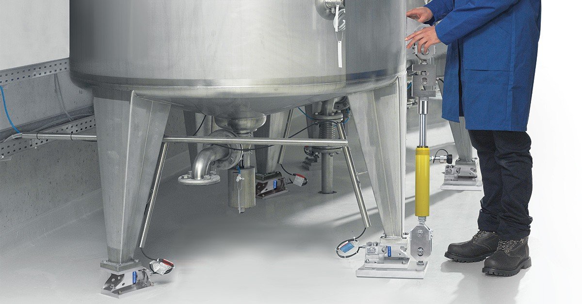 Industrial silos with load cell mounting hardware at a Saudi cement or chemical plant